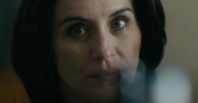 a close up of a woman 's face with smoke coming out of her mouth .