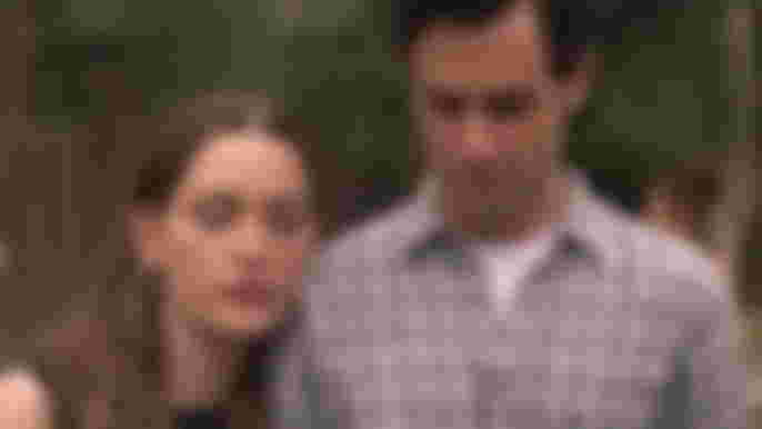 Victoria Pedretti as Love Quinn leans on Penn Badgley as Joe Goldberg in You