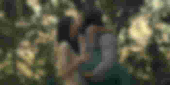 Billy and Camila kissing, with Billy carrying his daughter Julia
