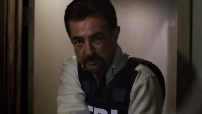 Criminal Minds Joe Mantegna as David Rossi holding a gun and wearing FBI vest