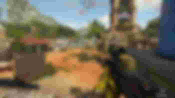 A player holding a sniper rifle at the ready while overlooking a large open plaza area on Pueblito, one of the XDefiant maps.