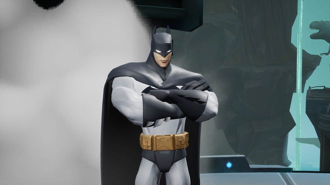 a statue of batman is standing in a room with his arms crossed .
