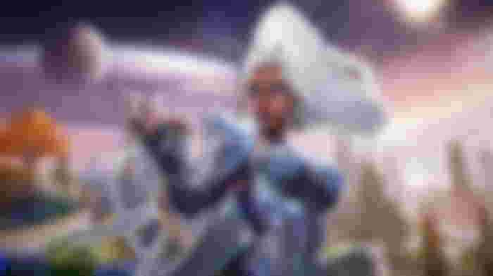 Storm from Marvel Rivals posing with her right arm outstretched, placed above a blurred background of the Asgard map.