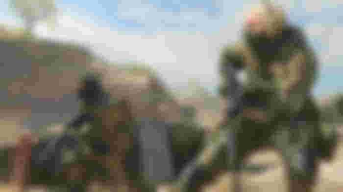 Modern Warfare 3 player pointing sniper rifle at ground with squadmate in background