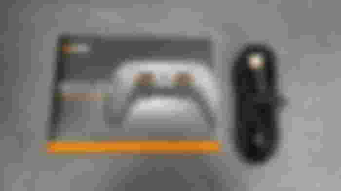 A black USB cable with orange trim next to SCUF Reflex Pro instructions.