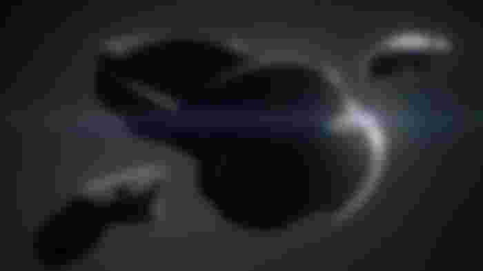 A black VR headset with a white light shining from behind it.