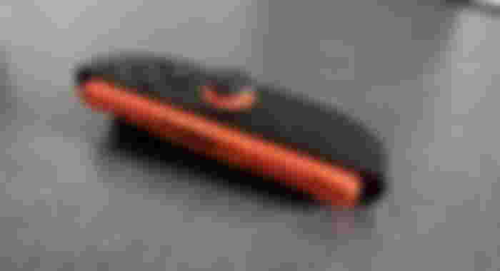 Switch 2 Joy-Con in black with orange trim.