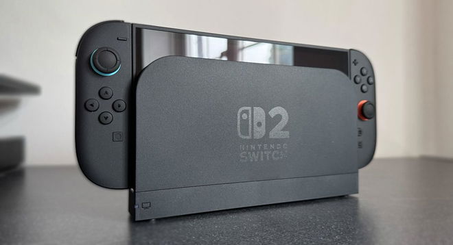 A black Nintendo console placed in its charging dock, with a blue ring around the left thumbstick, and an orange circle around the right thumbstick.