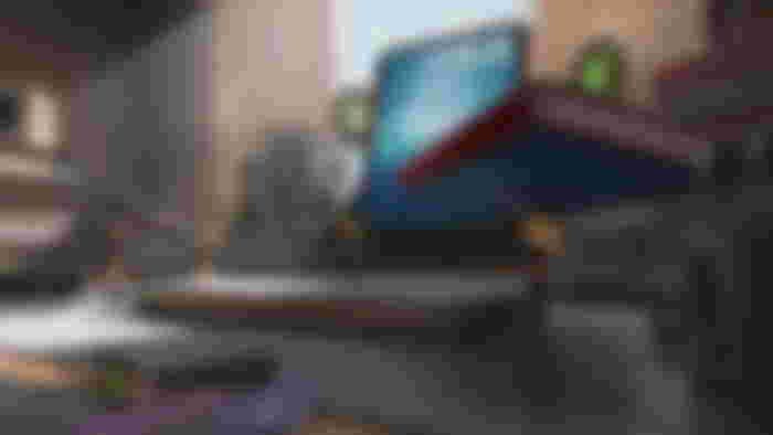 Screenshot from Figure Fantasy, showing several small figurines carrying a book on a desk