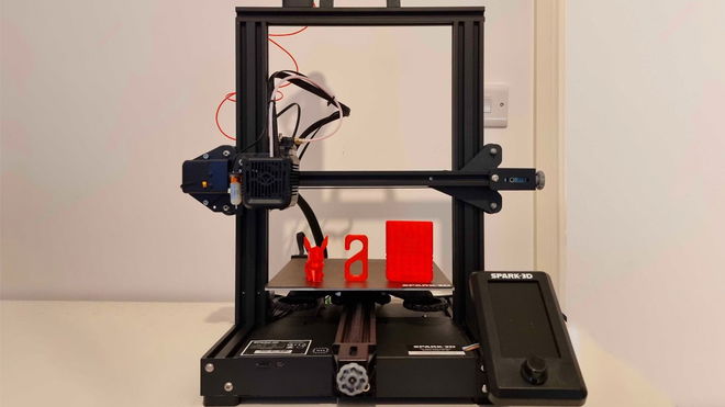 The Spark 3D S1 printer on a table with two prints on the bed. 