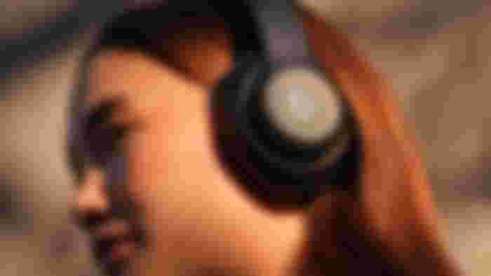 Women wearing Beats Studio Pro headphones.