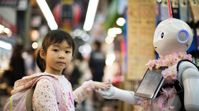 a little girl, making friends with a robot.