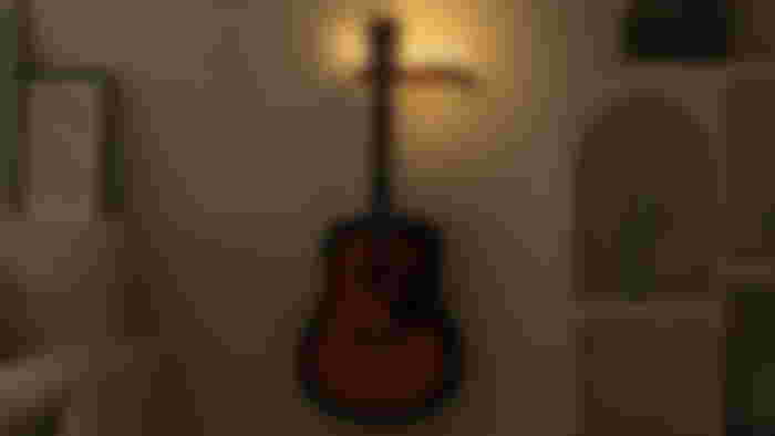 CoolGift Mart Guitar Stand Wall Mount on a wall with lights on top and a dark brown guitar hanging from it.