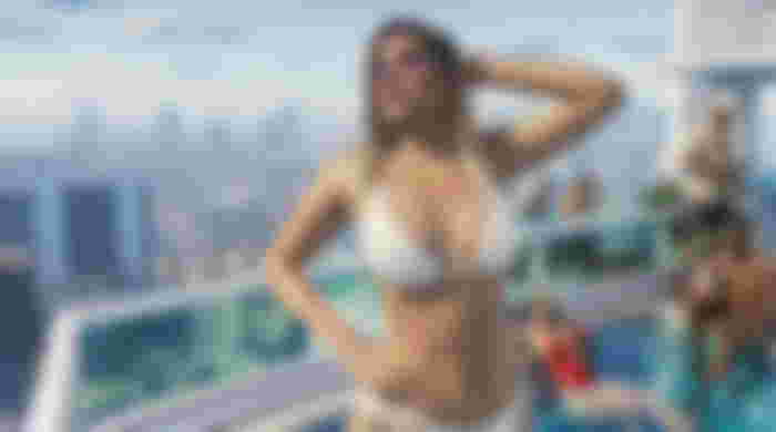 GTA 6 screengrab, woman in bikini stands near rooftop pool