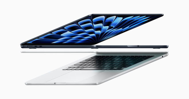 A Midnight-coloured 15-inch MacBook half open above a silver 13-inch MacBook.