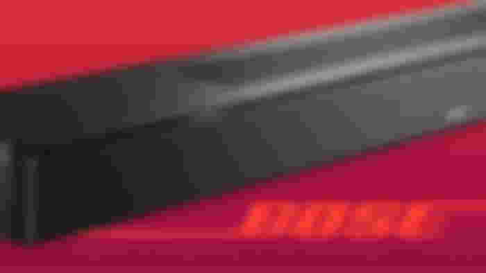 A close-up of a black soundbar above orange Bose branding.