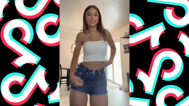 An image of a girl in a white tube top and jean shorts dancing confidently in a room, with the TikTok logo pattern in the background.