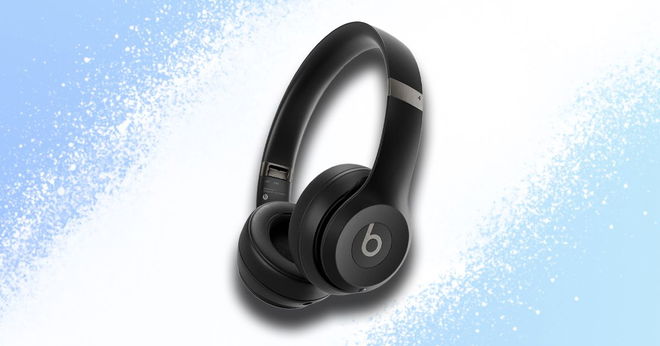 A black pair of beats headphones with a white spray in the background in front of a light blue background.