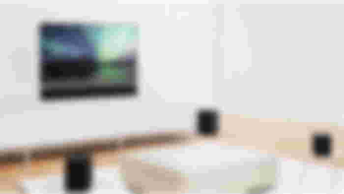 Image of a flatscreen TV featuring a North Lights screen in a living room filled with white furniture and black speakers.