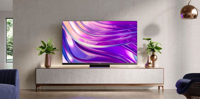 Image of a TV placed on a grey and gold stand between two plants featuring a purple pattern on the display.