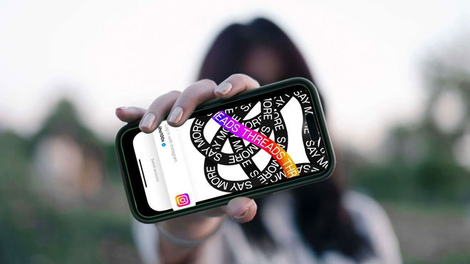 What is the Threads app for? - An image of a person showing a smartphone to the camera with the Threads app opened in it.
