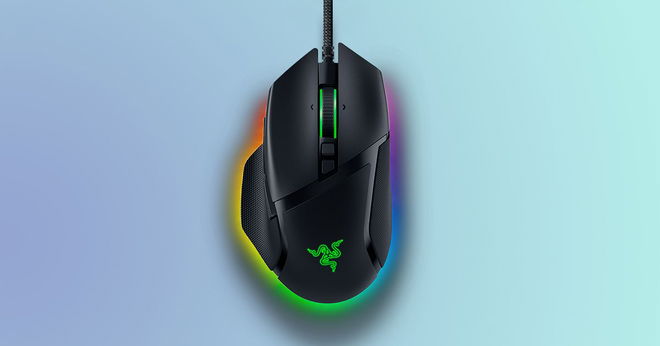 A black wired gaming mouse featuring green lighting on top and RGB lighting underneath in front of a light blue and turquoise background.