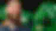 Post Malone smiling from Spotify art in front of the Backbone One x Post Malone green controller