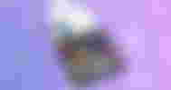 A black box with multicolored lines making up numbers inside it in front of a purple and pink snowy background.