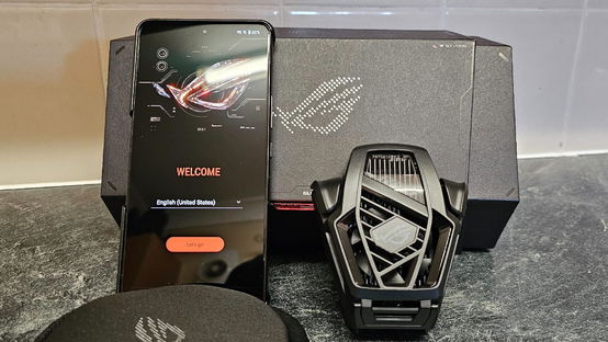 ASUS ROG Phone 8 Pro with Cooler next to it and the box behind it