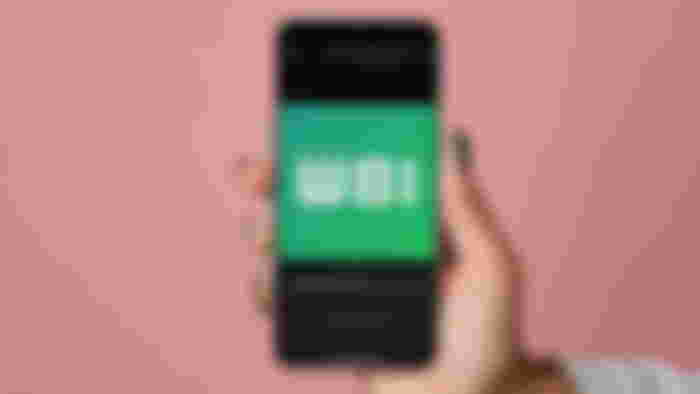 Whatsapp Status music on a phone held in someone's hand.