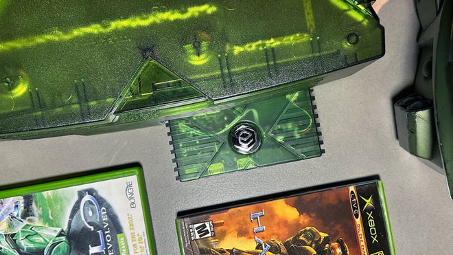 A green EON Gaming XBHD Xbox HDMI adapter in the back of a Halo: Special Edition OG Xbox surrounded by Halo games