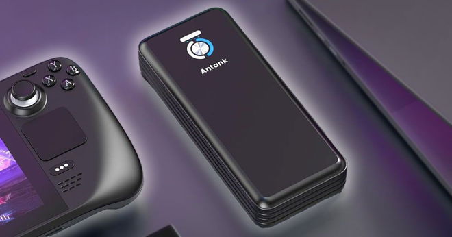 A black rectangular power bank with a white and blue detail on top next to a laptop and Steam Deck.