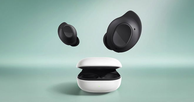 A pair of black Samsung earbuds above their white carry case in front of a light green background.
