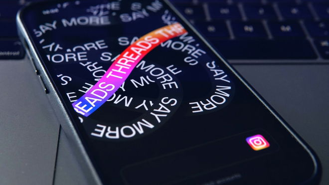 Threads typed out multiple times of a smartphone, with one line highlighted in the Instagram logo's colors.