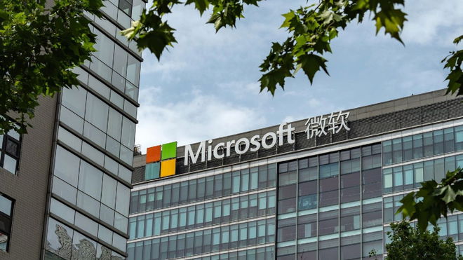 A large Microsoft office building with Chinese letters next to the main logo, with parts of trees surrounding the frame of the image