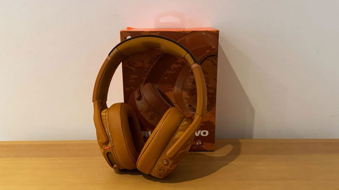 A set of Washed Tan camo over-ear headphones in front of their box.
