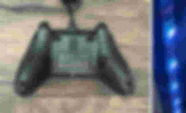 The back of a black PowerA Advantage Xbox controller featuring back buttons next to an image of blue strip lights.