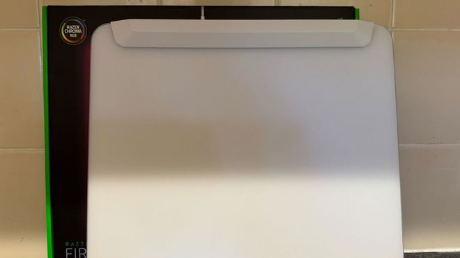 The Razer Firefly V2 Pro white mouse pad in front of the box and a tiled wall