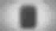 A rectangular Google speaker with curved edges in front of a gray paint-splattered background.