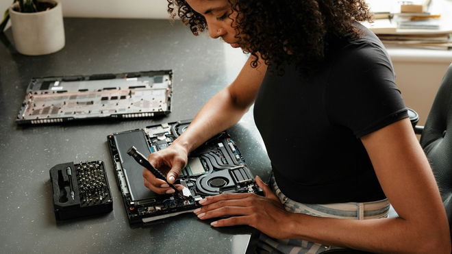 Girl changing SSD in laptop.