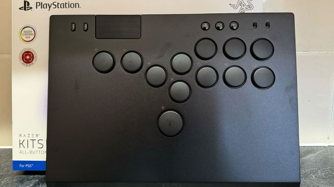 A Razer Kitsune arcade controller standing up in front of its bo