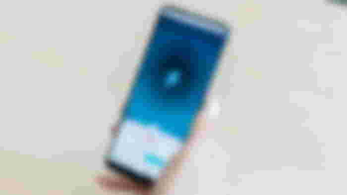 Someone using a black phone with Surfshark loaded up on it.