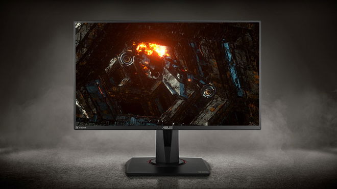 A black monitor in a dark grey room with a space ship flying away from an explosion on the display.