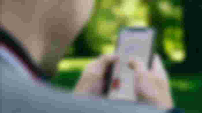 An image of a man using an iPhone.
