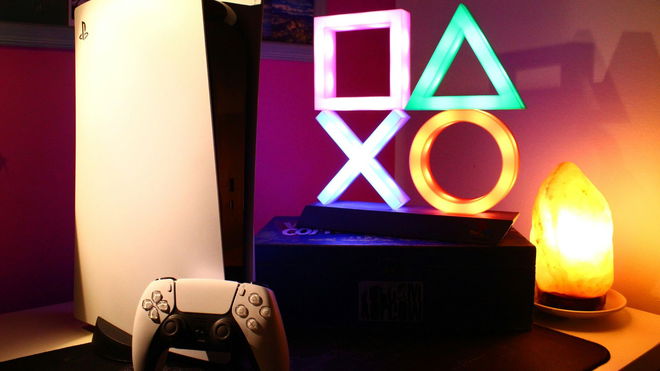 PlayStation 5 in warm light and a lamp representing playstation button icons on the side.
