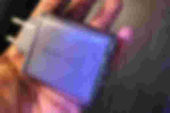 A grey multiport USB charger with a clear outer casing.