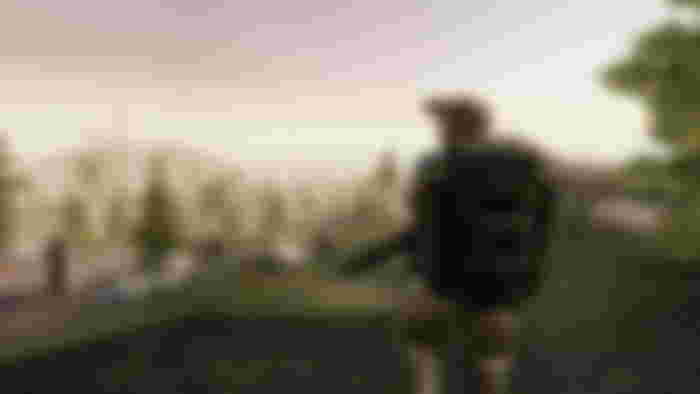 Ghosts of Tabor player surveying an open area with trees, a lighthouse present in the distance.