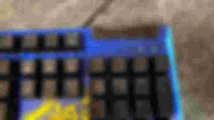 A close up of the Razer x Fortnite BlackWidow V4 X, highlighting the blue print and yellow loot pinata near the numpad and the volume wheel