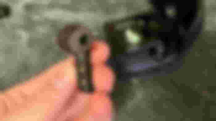 Holding an ASUS ROG Cetra earbud with the case open behind my hand