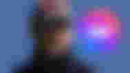 Joe from the TV show You wearing a Netflix hat and looking at the messenger logo